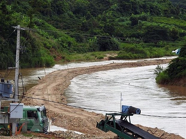 Công ty TNHH 87 tự ý dùng phương tiện cơ giới mở lòng đường ra giữa sông để tiến hành khai thác cát ở thôn 7, xã Đăk Pxi, huyện Đăk Hà, tỉnh Kon Tum. (Ảnh: Cao Nguyên/TTXVN)
